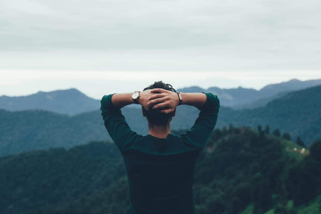 Former patient overlooking mountains looking back on the amazing journey he has just completed.