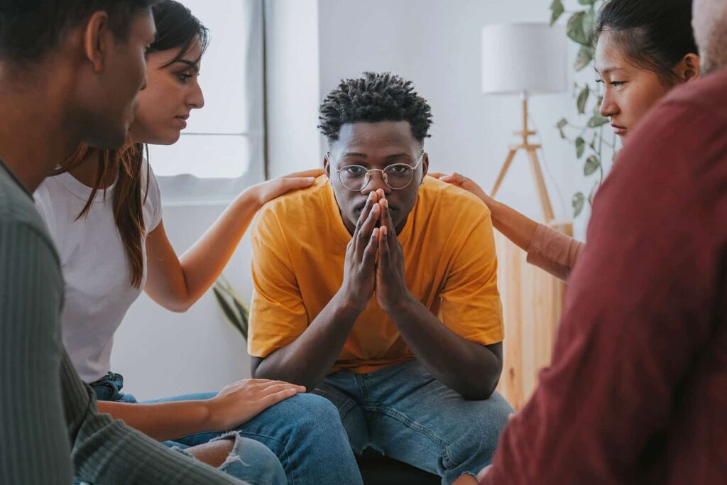 A group of residents console a fellow client who just finished a successful process group.